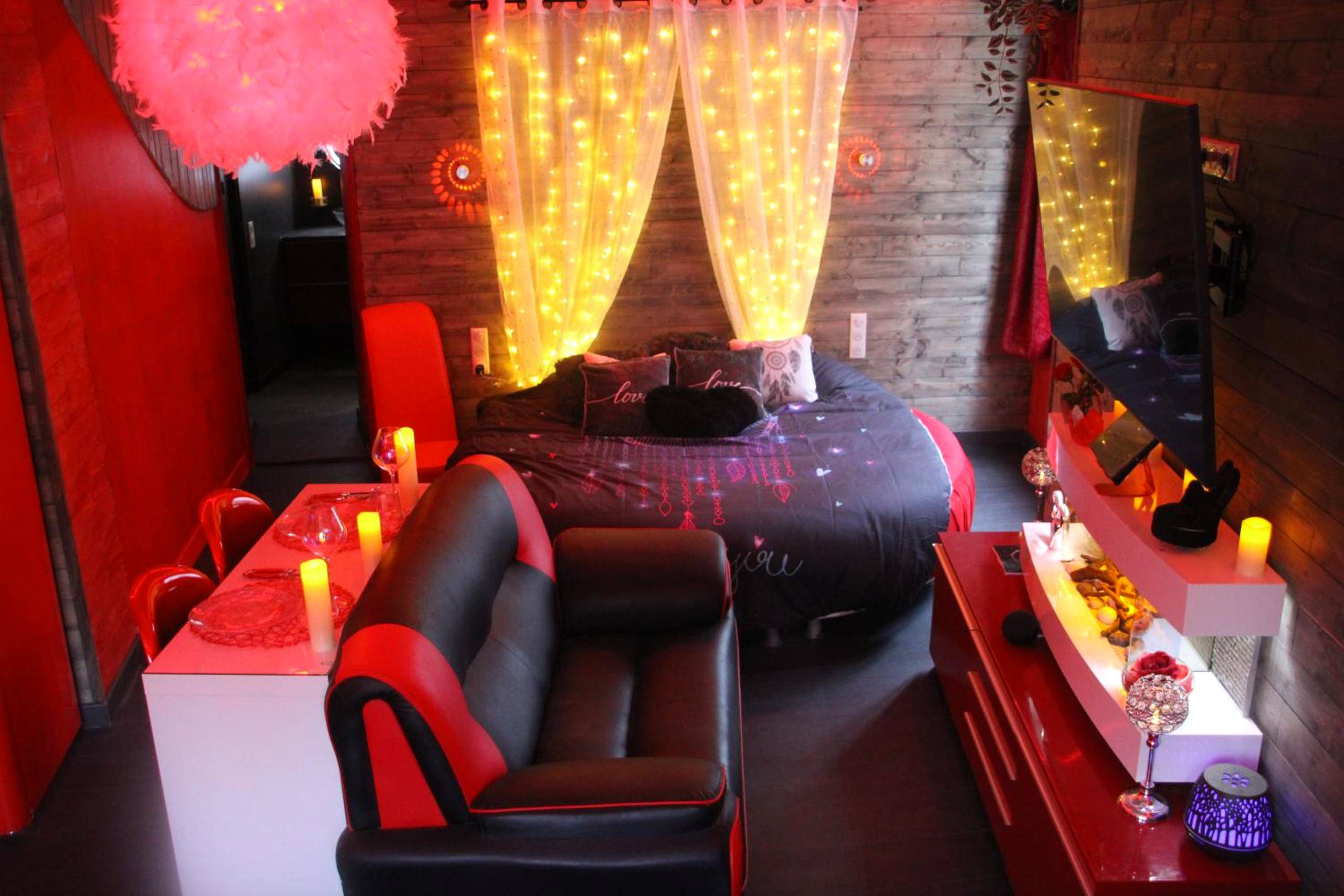 Lit rond et canapé dans une ambiance rouge - L'Attrape Rêves - Gîte Le Romantique