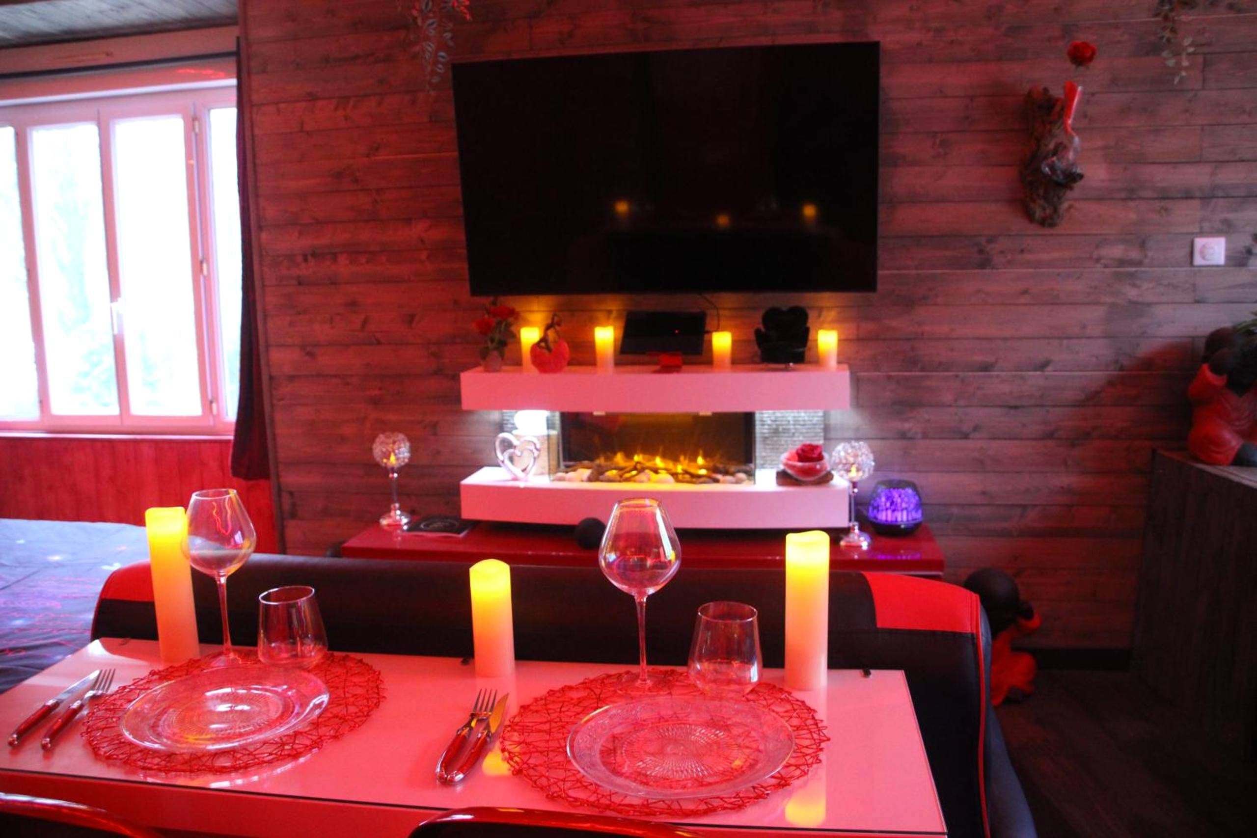 Table dressée face à une cheminée électrique - L'Attrape Rêves - Gîte Le Romantique