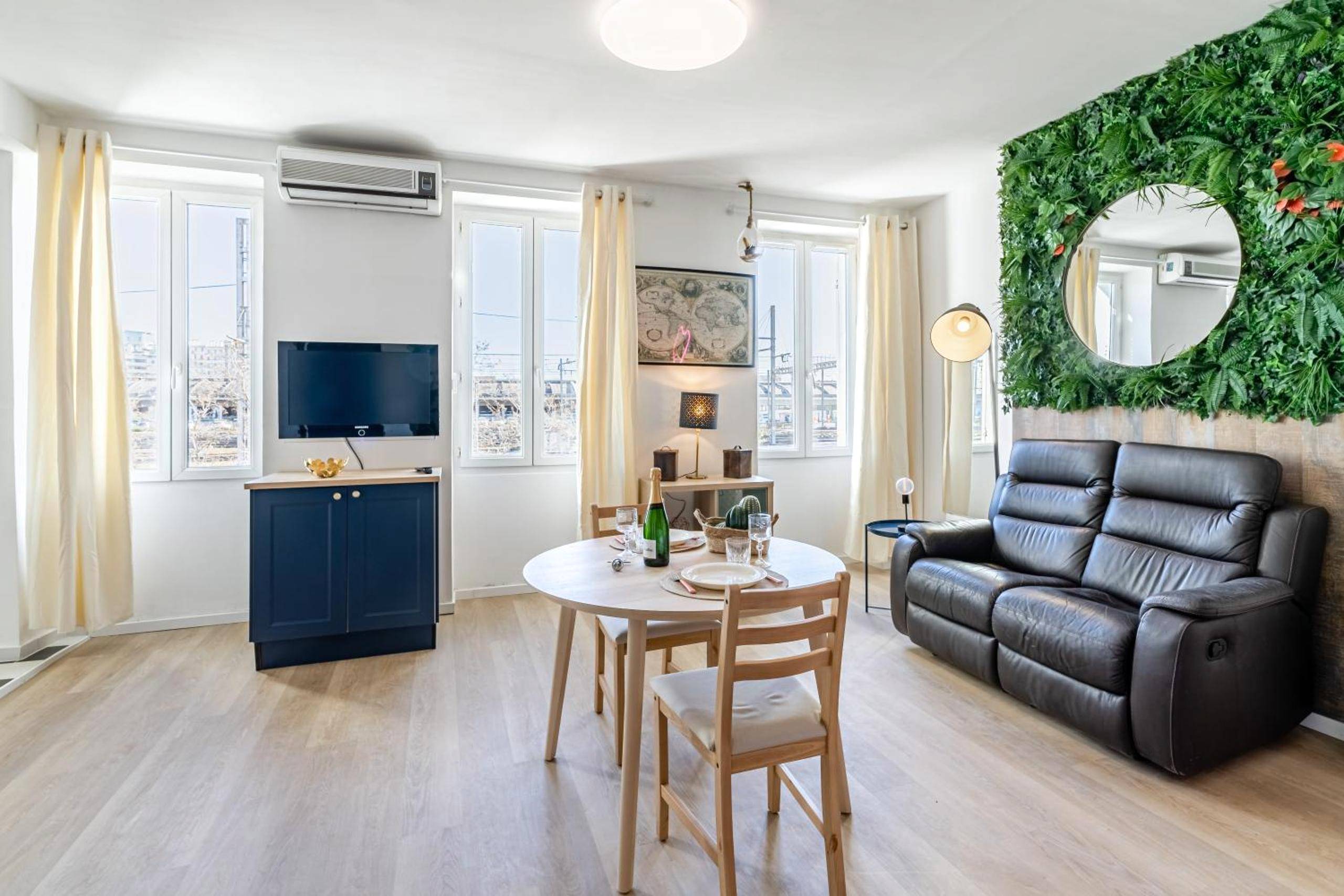 Salon lumineux avec canapé cuir et télévision - L'Étreinte Saint - Aurora Lov'Room Proche de Saint Charles