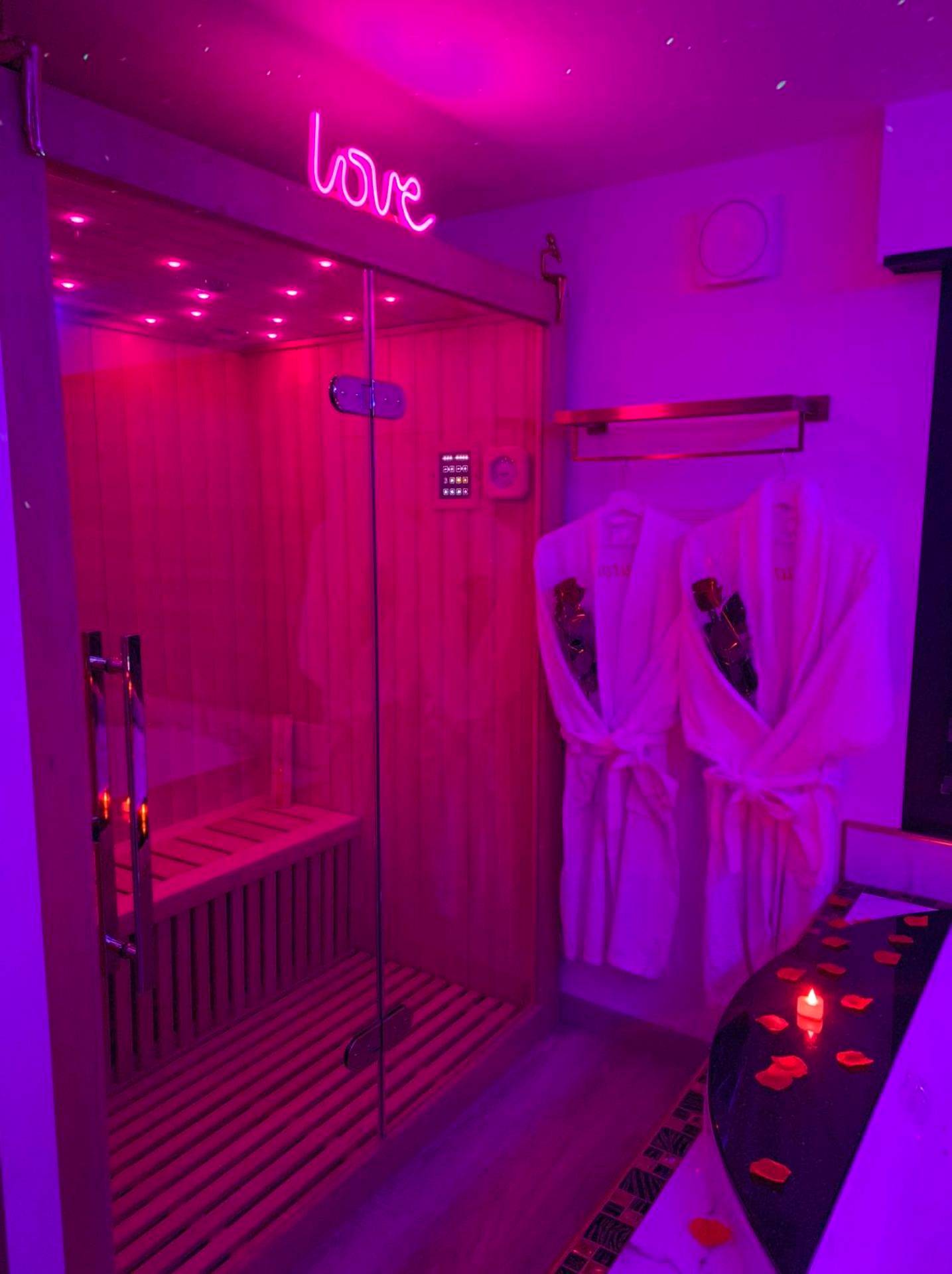 Sauna privatif avec éclairage néon rose - L'Aurore Love Room de prestige jacuzzi sauna piscine chauffée cuisine