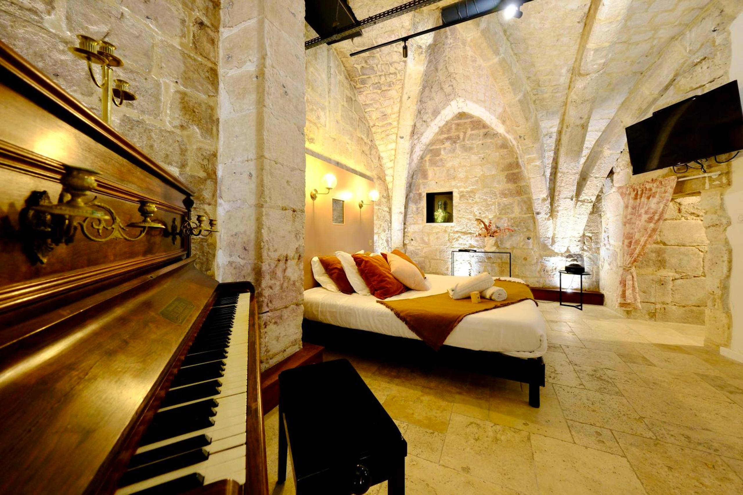 Chambre voûtée en pierre avec piano ancien - Love Room Rouen - L'Autel La Crypte Mystérieuse de Rouen - sauna & balnéo