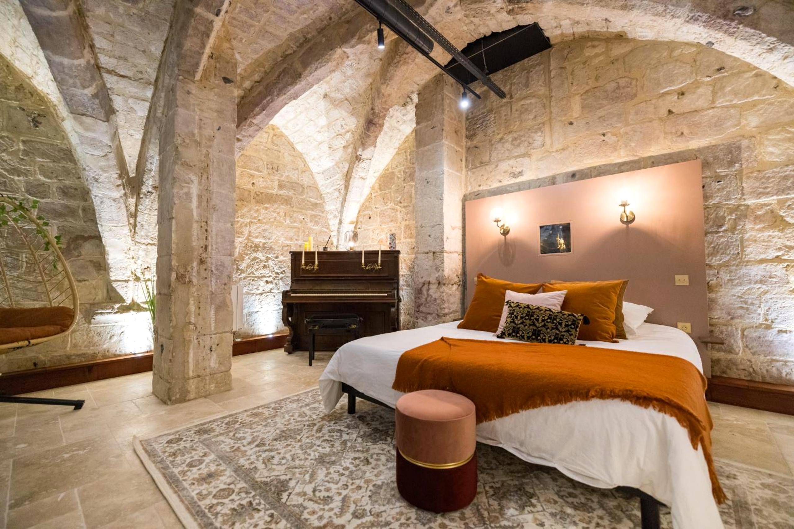 Lit double sous voûtes avec tête de lit rose - L'Autel La Crypte Mystérieuse de Rouen - sauna & balnéo