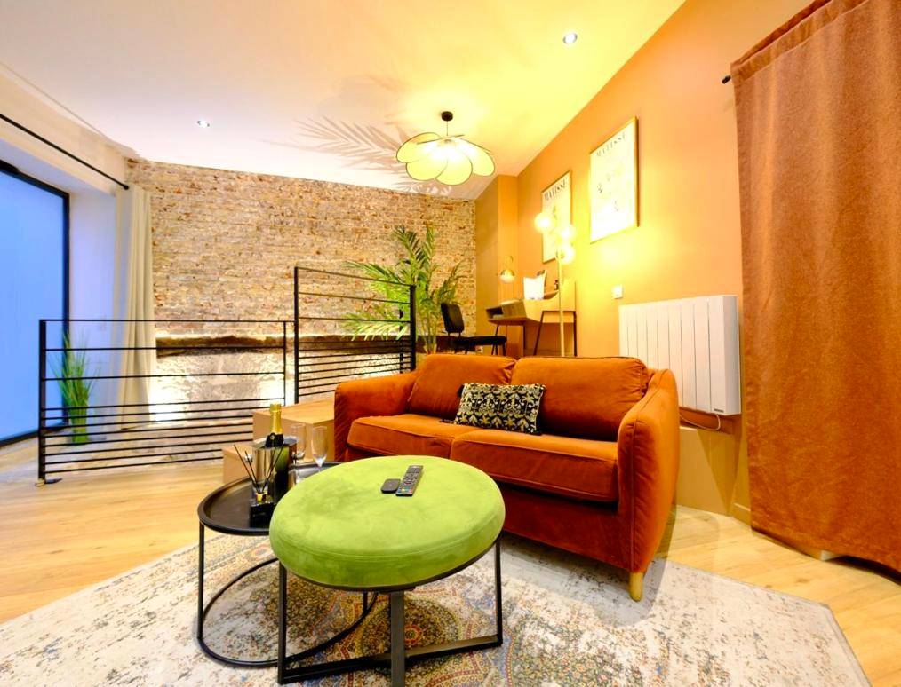 Salon avec canapé en velours et pouf vert - L'Autel La Crypte Mystérieuse de Rouen - sauna & balnéo