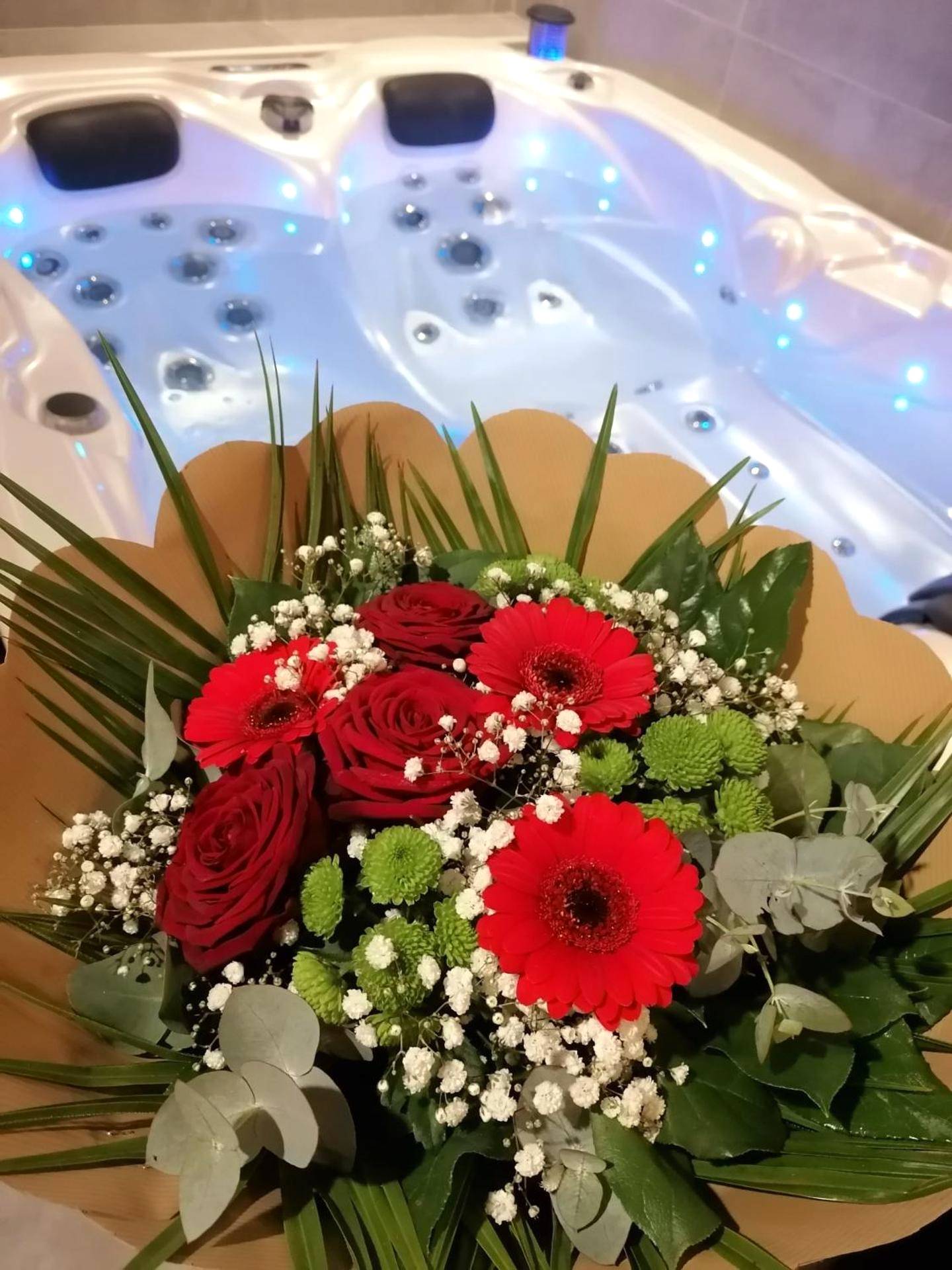 Bouquet de fleurs devant un jacuzzi éclairé - Autrement Spa
