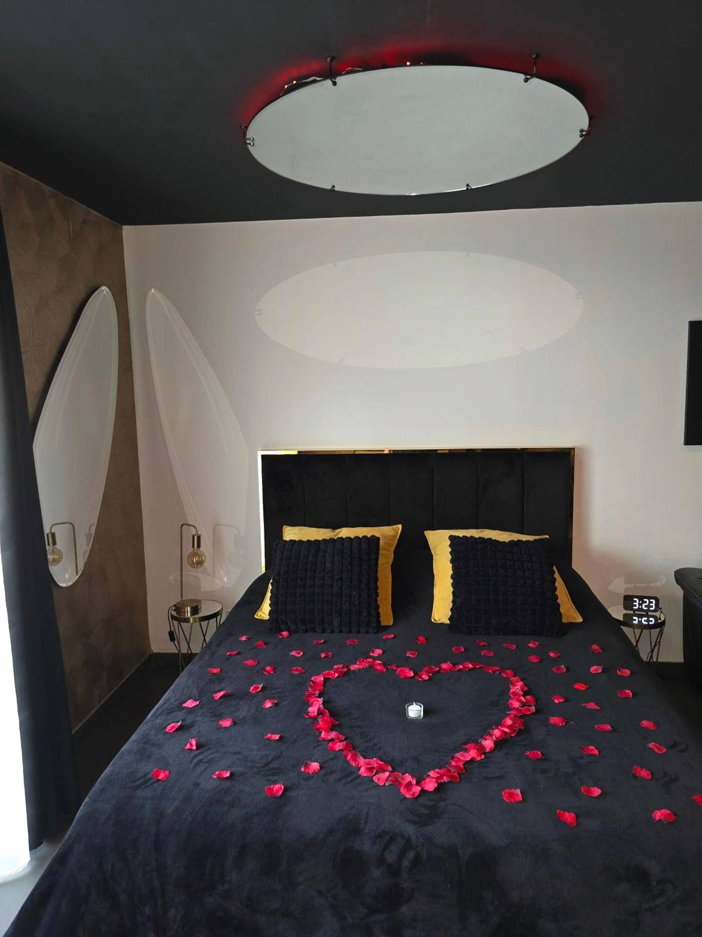 Lit double avec pétales de rose en cœur et miroir - Avec toi suite spa La Secrète