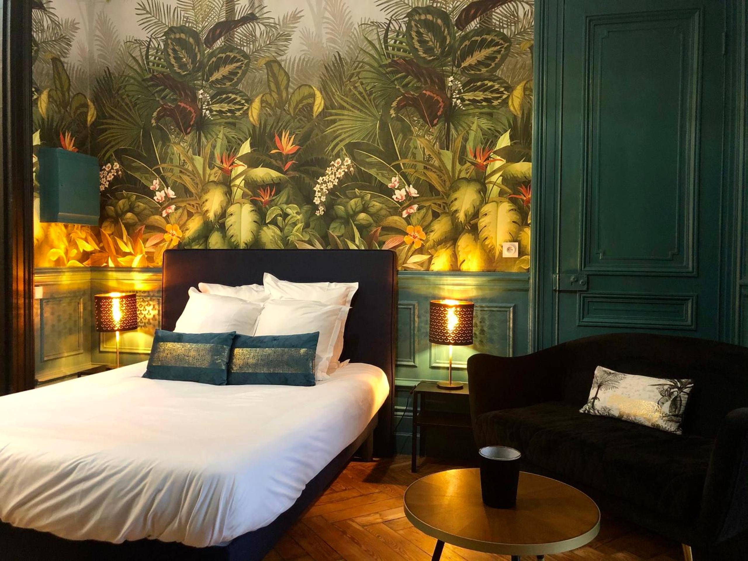 Lit double devant un papier peint jungle - Love Room Calais - Le Ba Roc