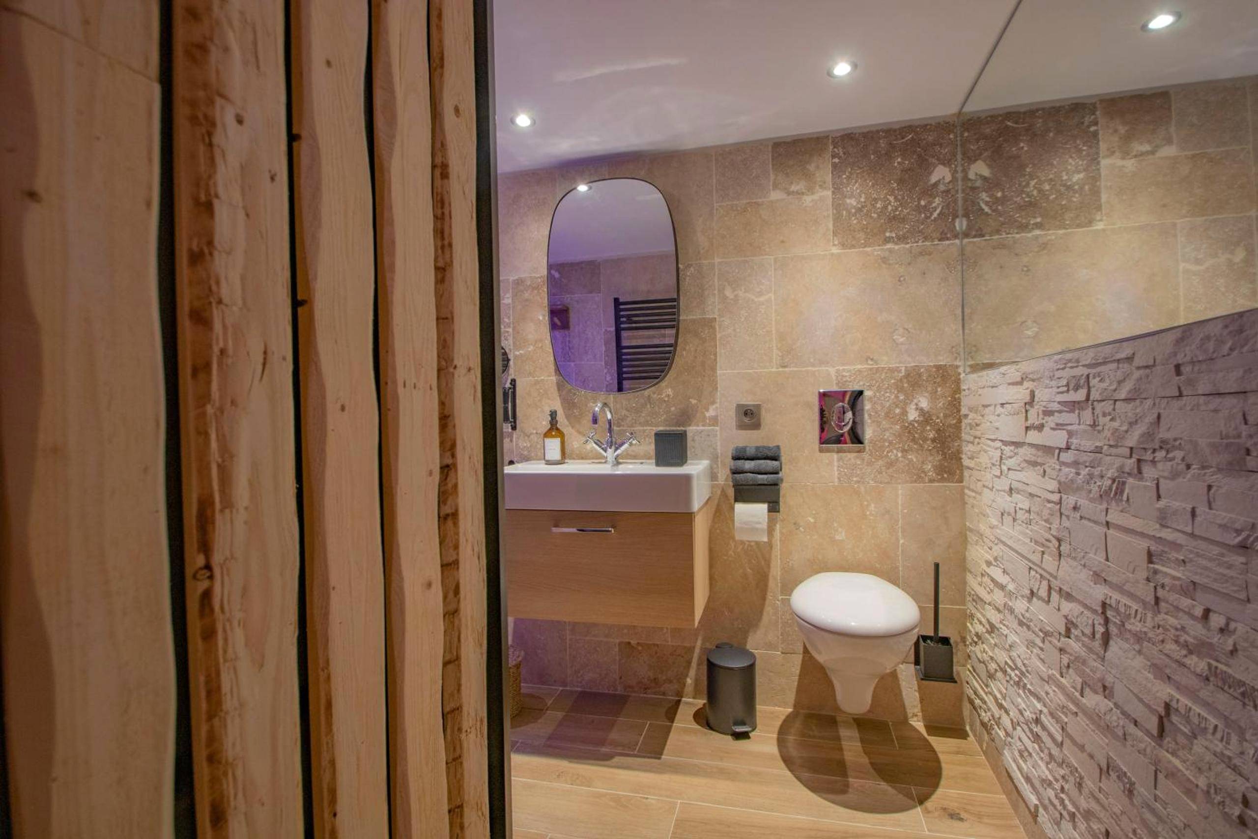 Toilettes suspendues et mur en pierre - LES BAINS D’EROS