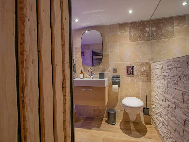 Toilettes suspendues et mur en pierre - LES BAINS D’EROS