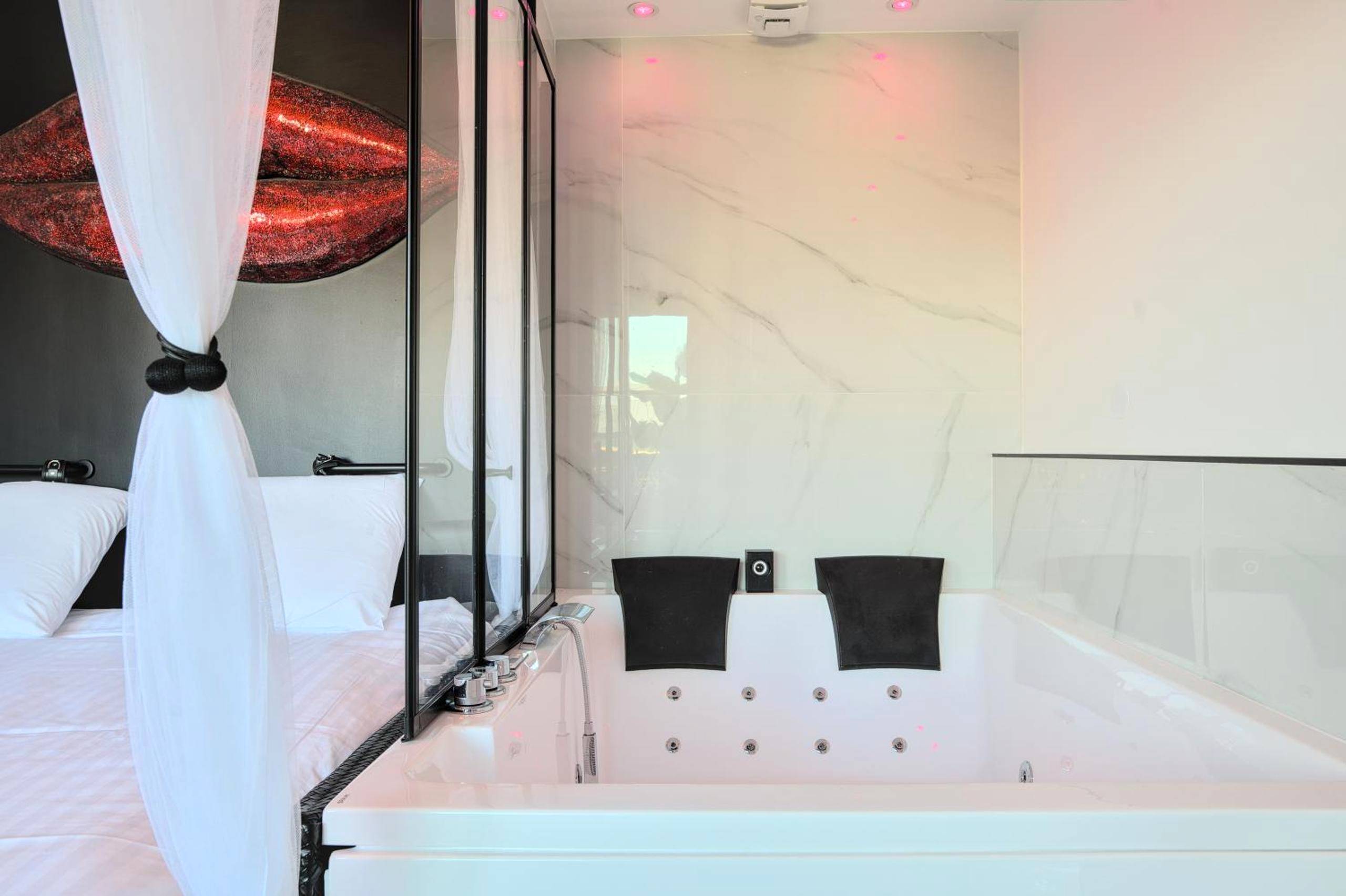 Jacuzzi privatif et lit avec voilages blancs - Love Room Metz - Le balcon romantique