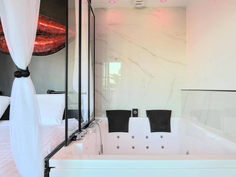 Jacuzzi privatif et lit avec voilages blancs - Love Room Metz - Le balcon romantique