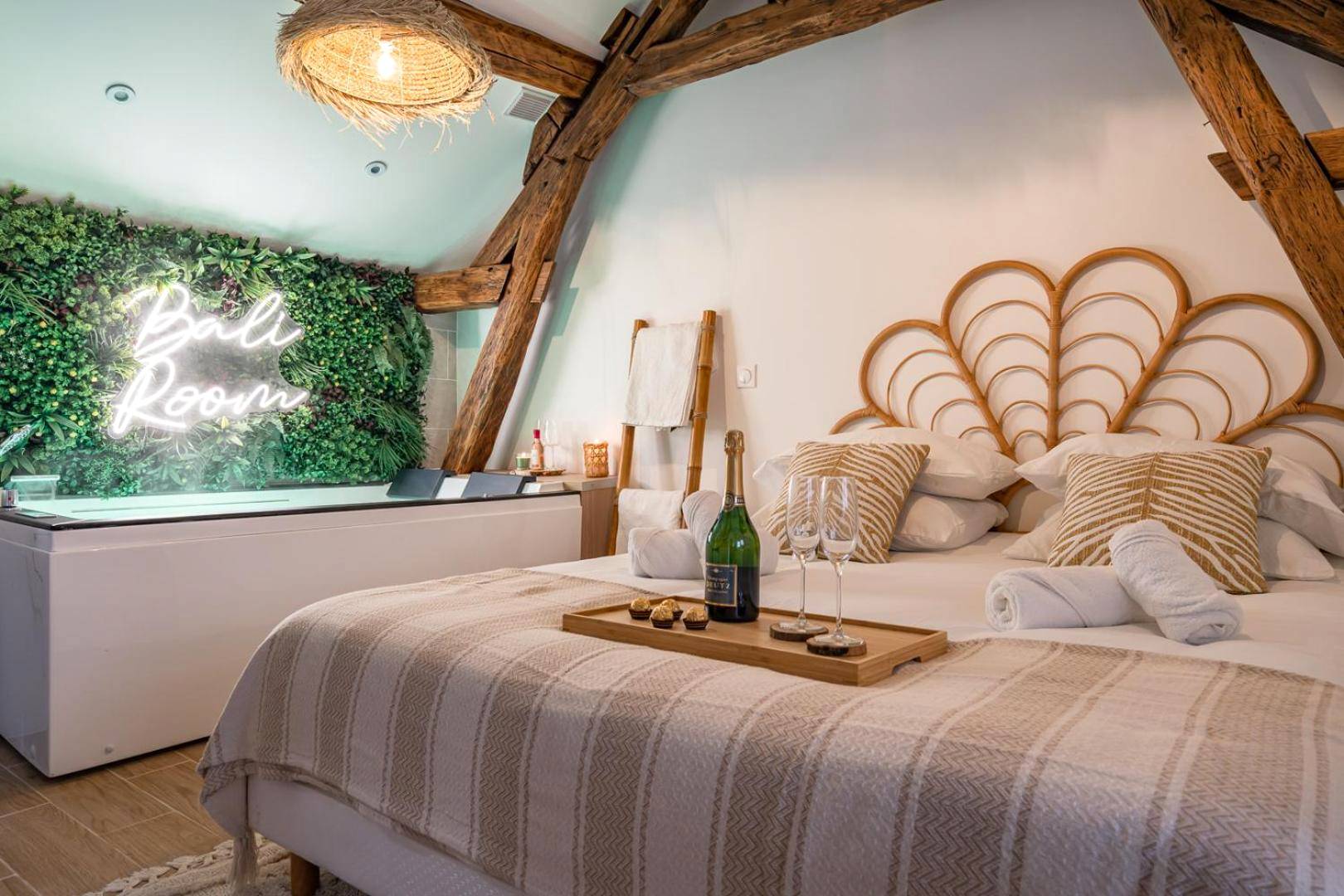Lit double et jacuzzi sous charpente apparente - Love Room Montgeron - BALI ROOM / Magnifique studio évasion JACCUZI