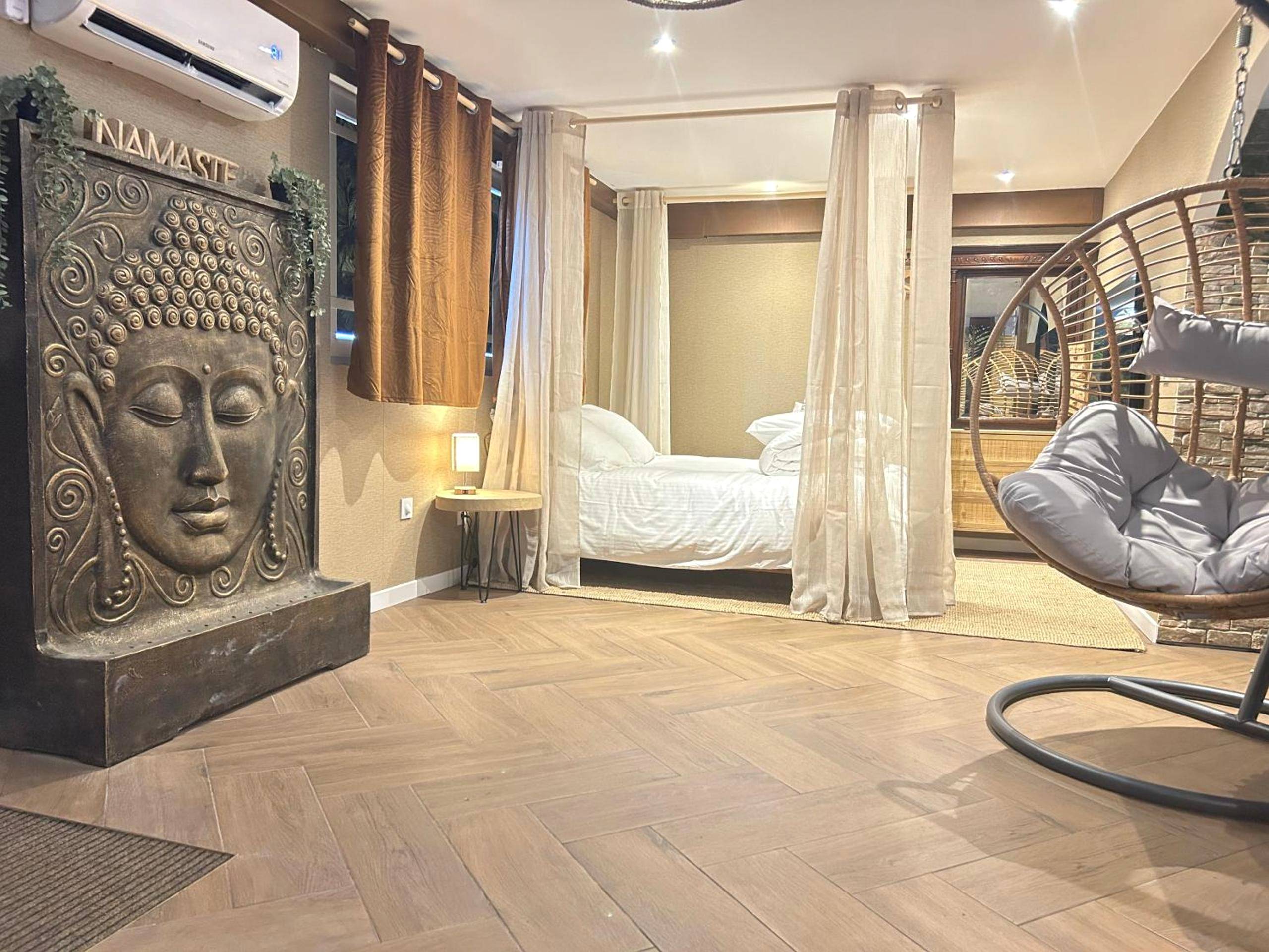 Chambre avec lit à baldaquin et statue Bouddha - La Balinaise, a Normandy getaway