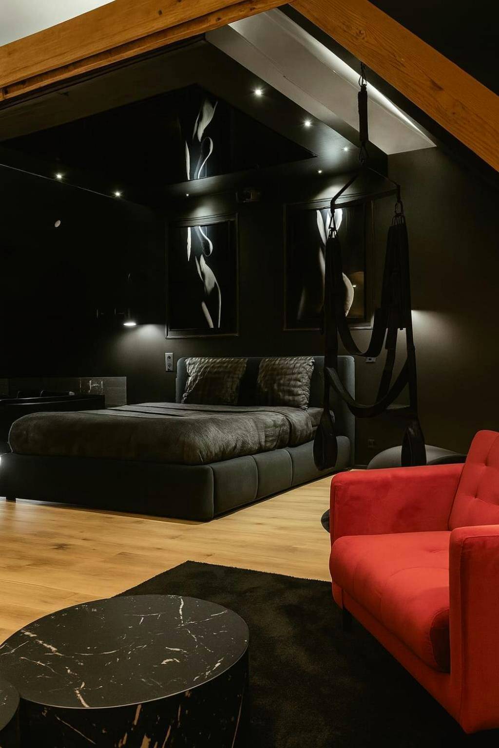 Chambre sombre avec balançoire et fauteuil rouge - Love Room Lorient - Love Room - Balnéo - Parking privé