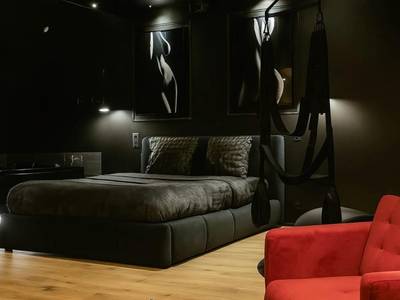 Chambre sombre avec balançoire et fauteuil rouge - Love Room Lorient - Love Room - Balnéo - Parking privé