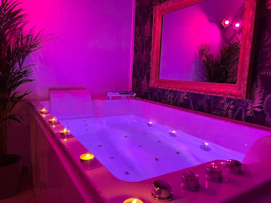 Jacuzzi avec bougies et éclairage rose - Love Room Dijon - La balnéo du Couvent