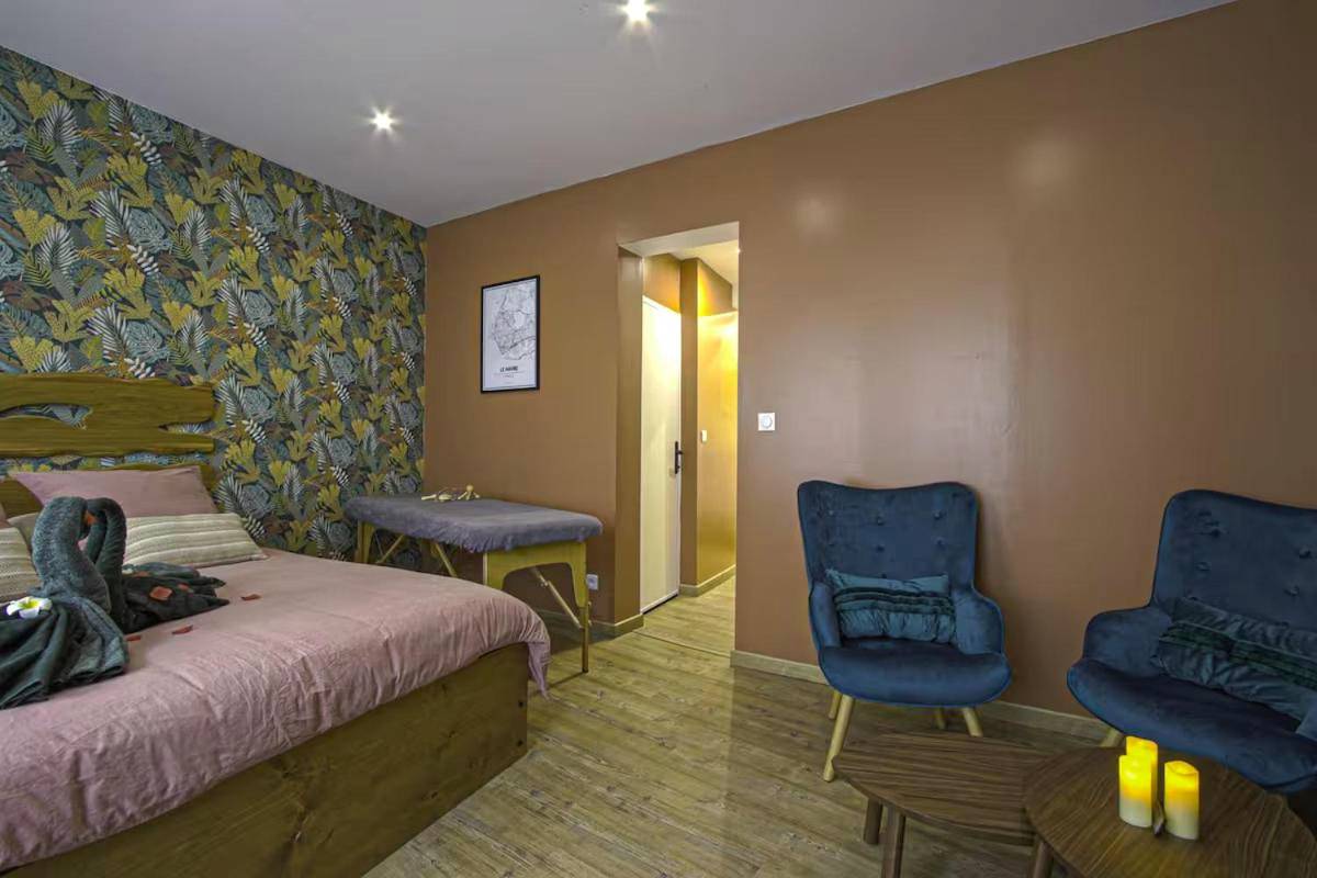 Chambre avec table de massage et fauteuils bleus - Love room balnéo sauna Le Havre