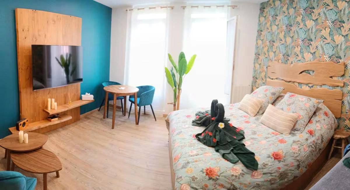 Lit double avec cygnes en serviettes et coin TV - Love room balnéo sauna Le Havre