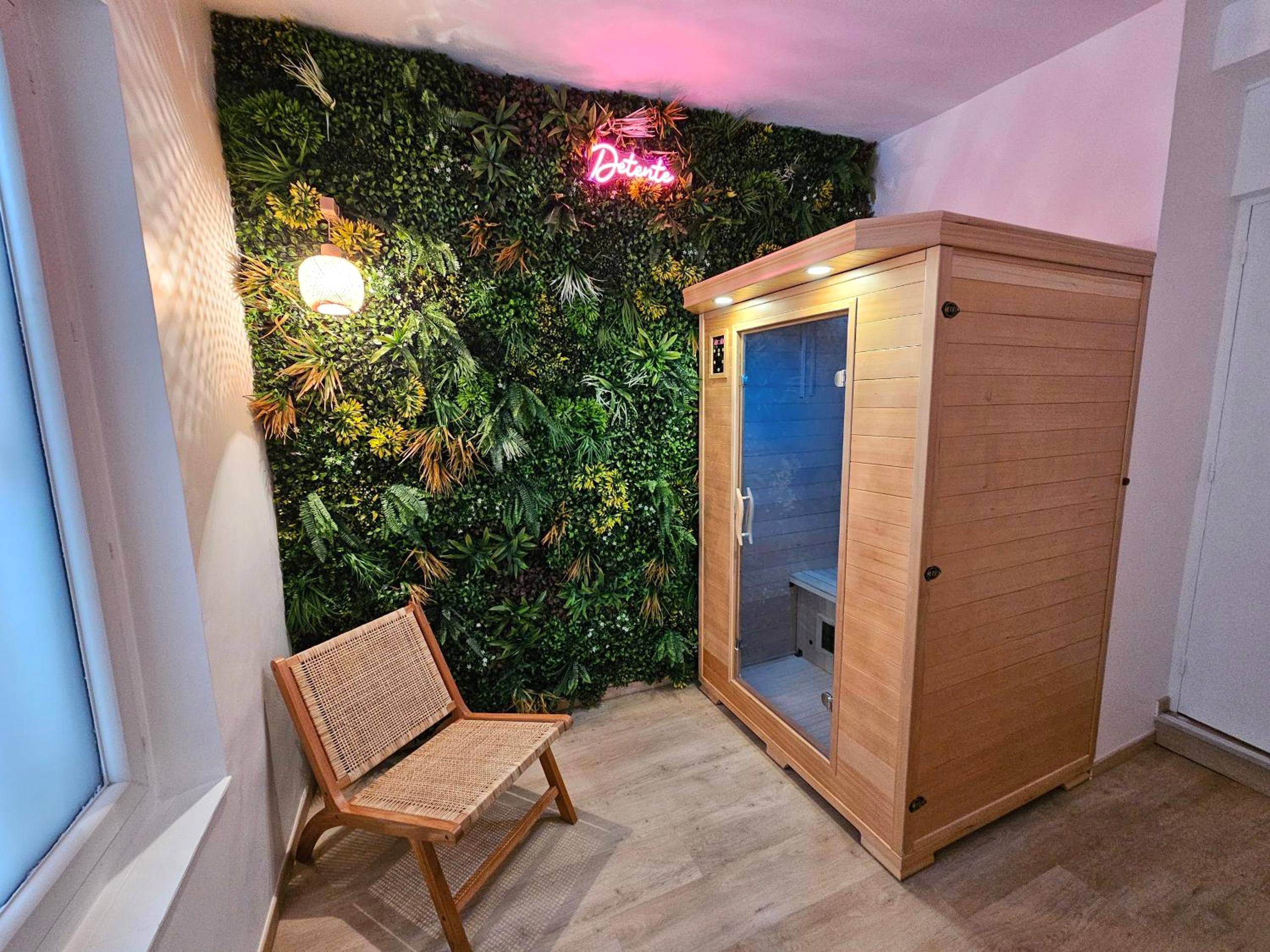 Sauna en bois et mur végétal avec néon - Love Room Carcassonne - Tout confort ! Balnéo, Sauna, Cinéma, Climatisation,...