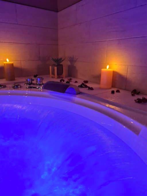 Jacuzzi avec éclairage bleu et bougies - Love Room Vesoul - Balnéo