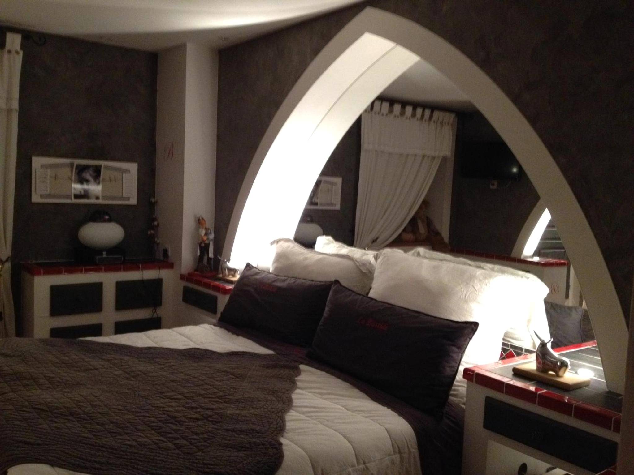 Chambre avec lit double et arche décorative - LA BASTIDE DES 3 AS & Spa