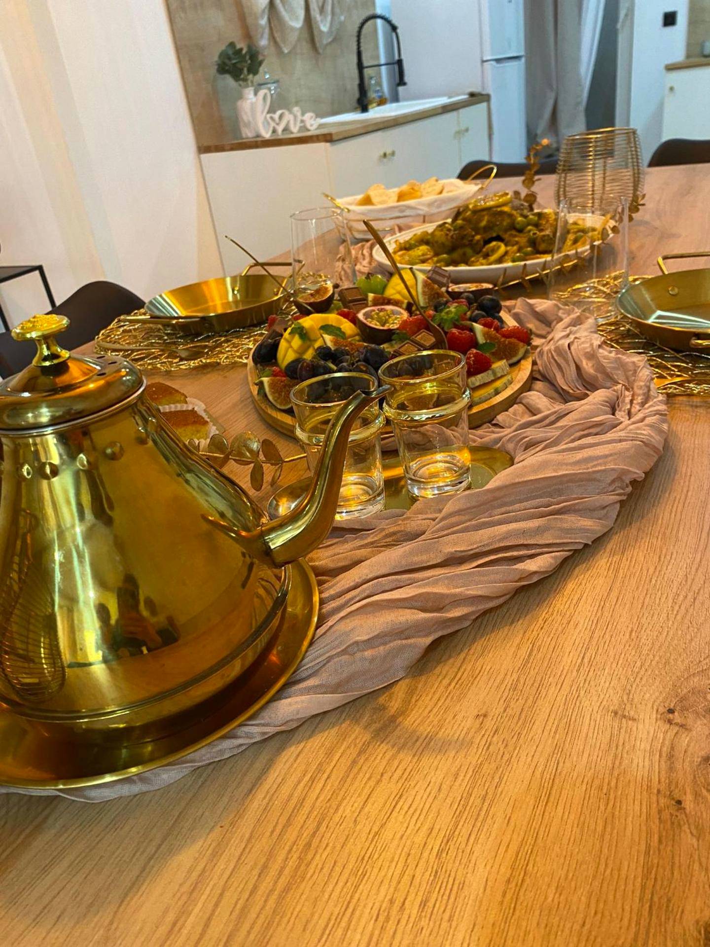 Table dressée avec théière dorée et fruits - La Belle Echapée