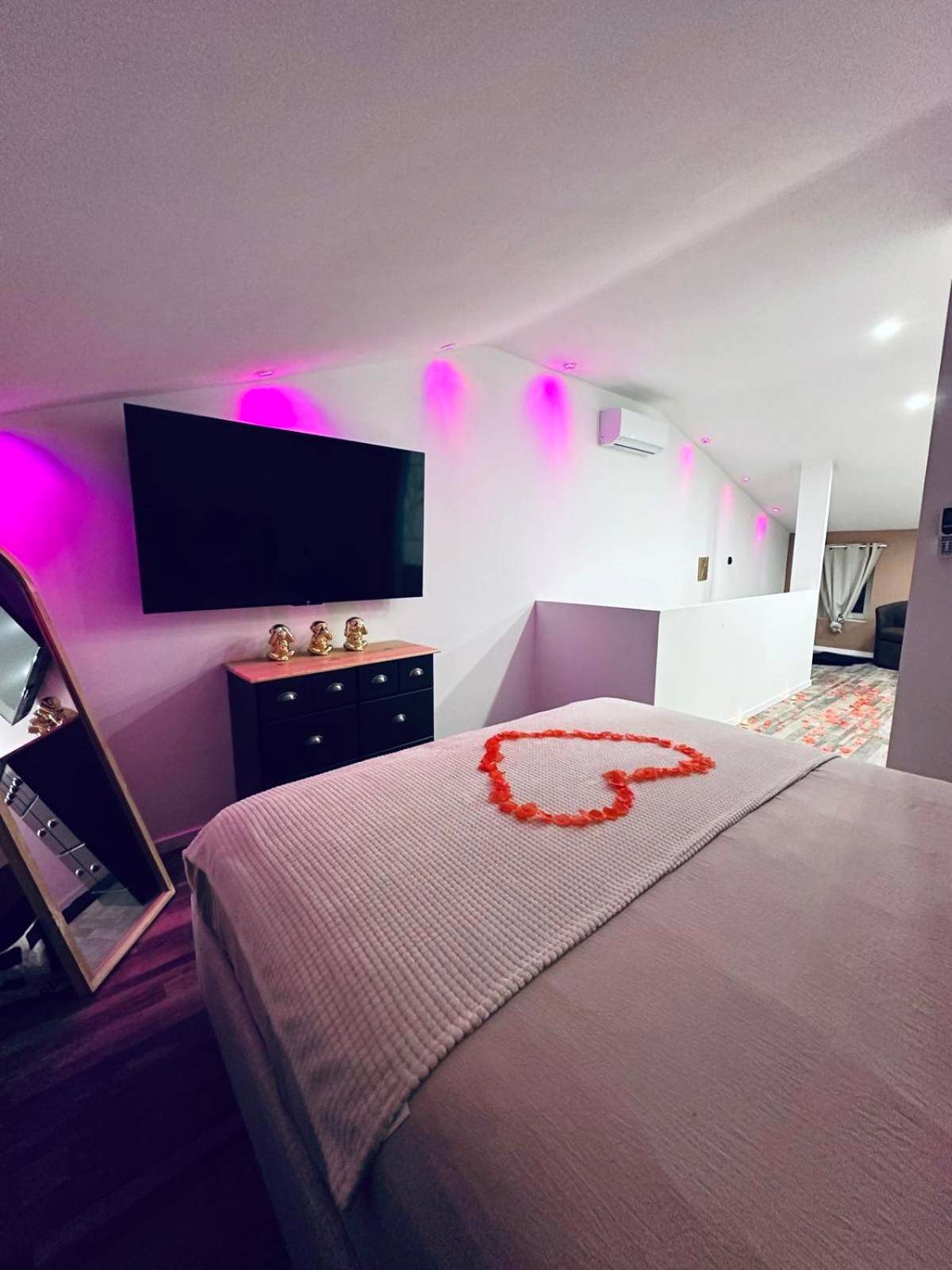 Lit avec cœur en pétales et éclairage rose - La Belle Echapée