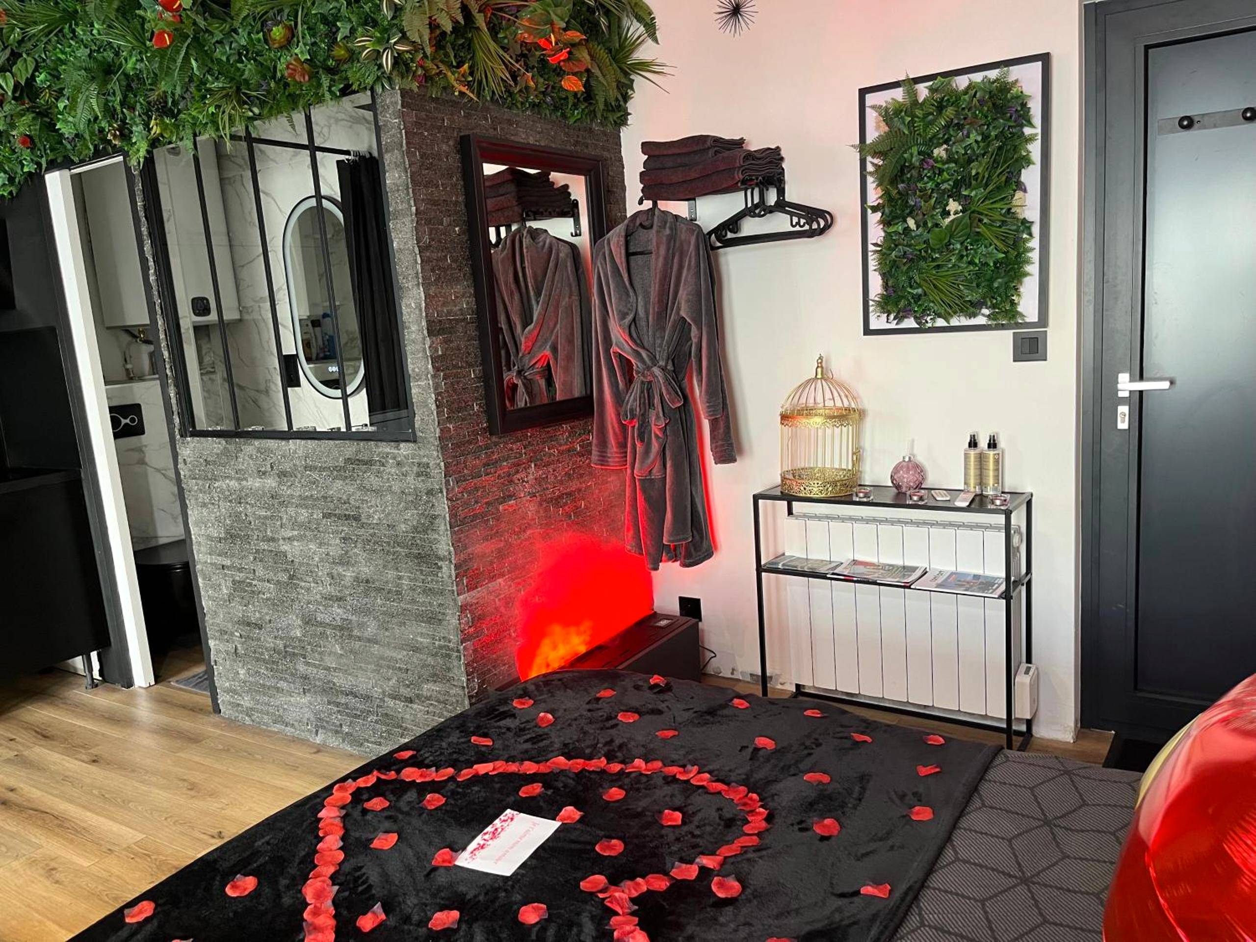 Lit avec pétales de rose et peignoirs - BelleRive Love Room