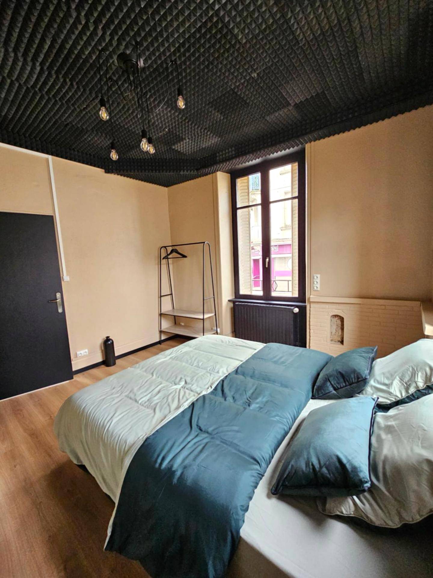 Chambre avec lit double et plafond acoustique - BLACK BOX CINEMA appartement avec balnéo