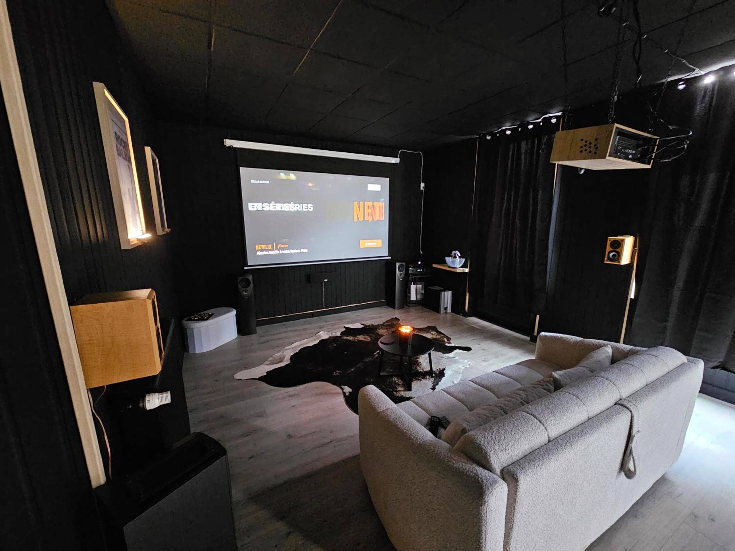 Salon home cinéma avec canapé et projecteur - BLACK BOX CINEMA appartement avec balnéo