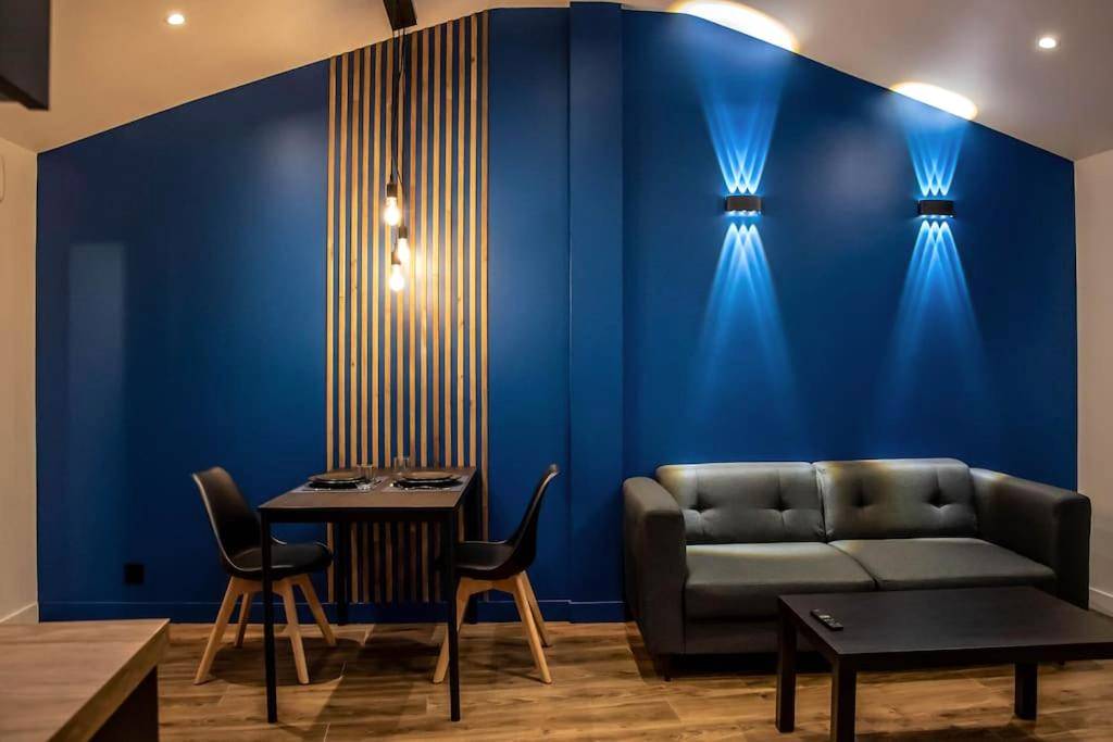 Salon avec canapé gris et mur bleu design - Love Room Corbeil - Essonnes - BLUE NIGHT - Jacuzzi - Bord de Seine