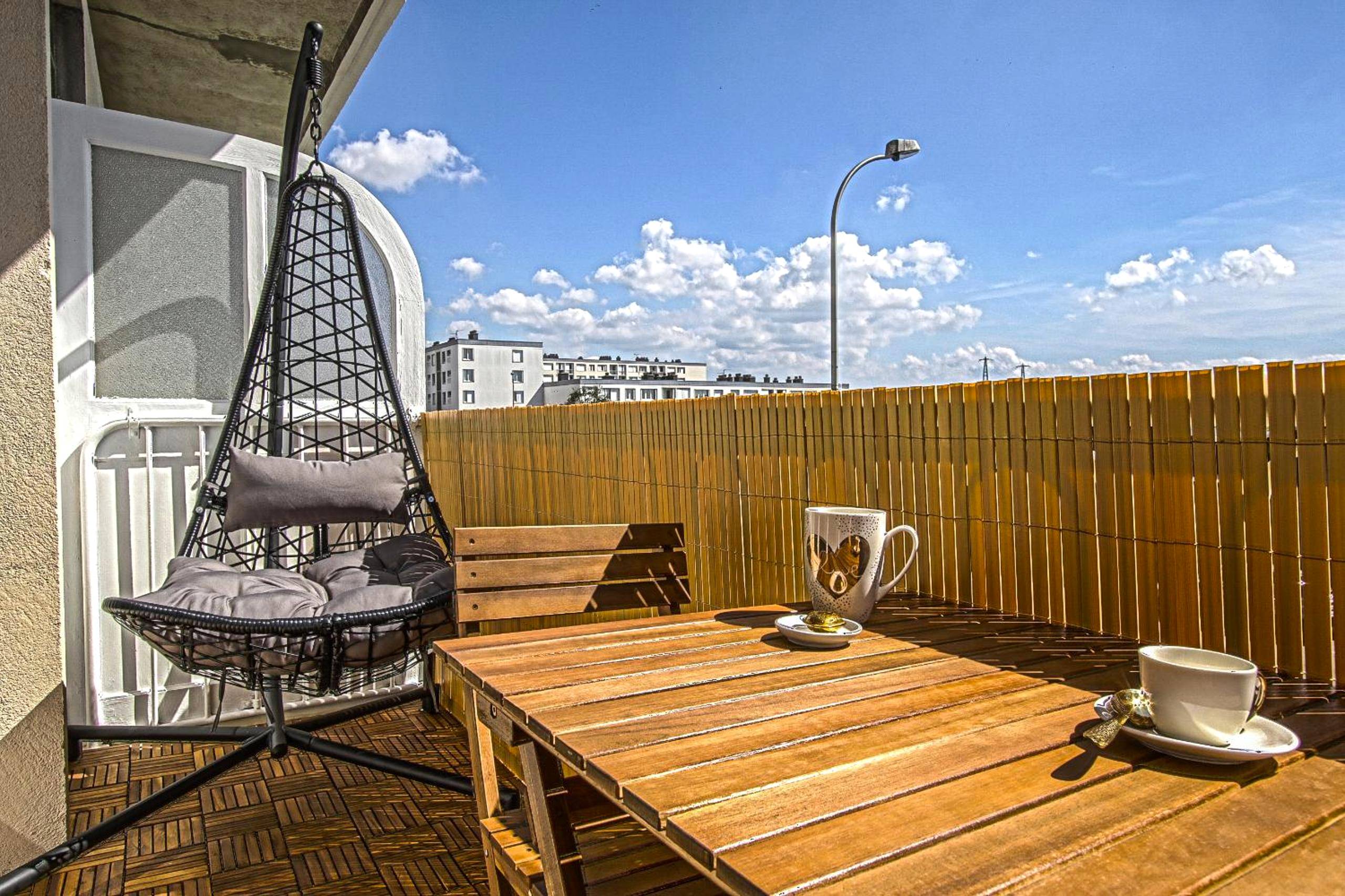 Balcon aménagé avec fauteuil suspendu et table - Le Boudoir de Fanny - Sauna/Balnéo/ciné/Hamacs