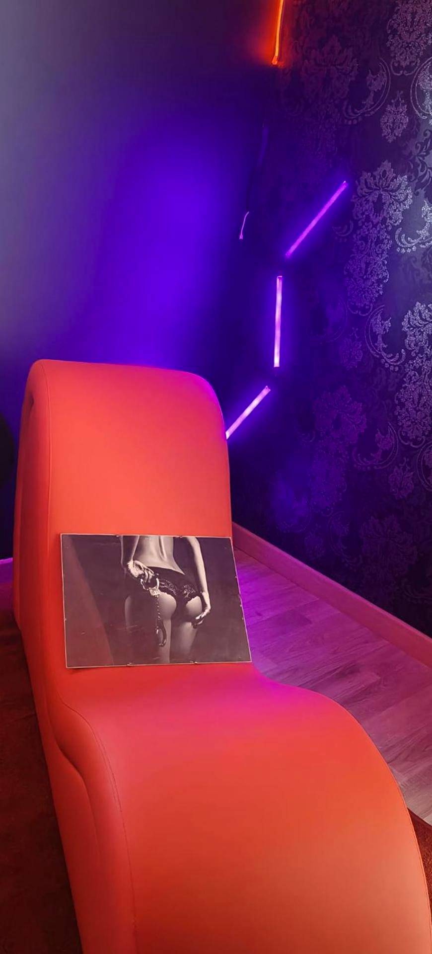 Fauteuil tantrique rouge et néons violets - Love Room Chasse - sur - Rhône - Le boudoir des jouissances perverses