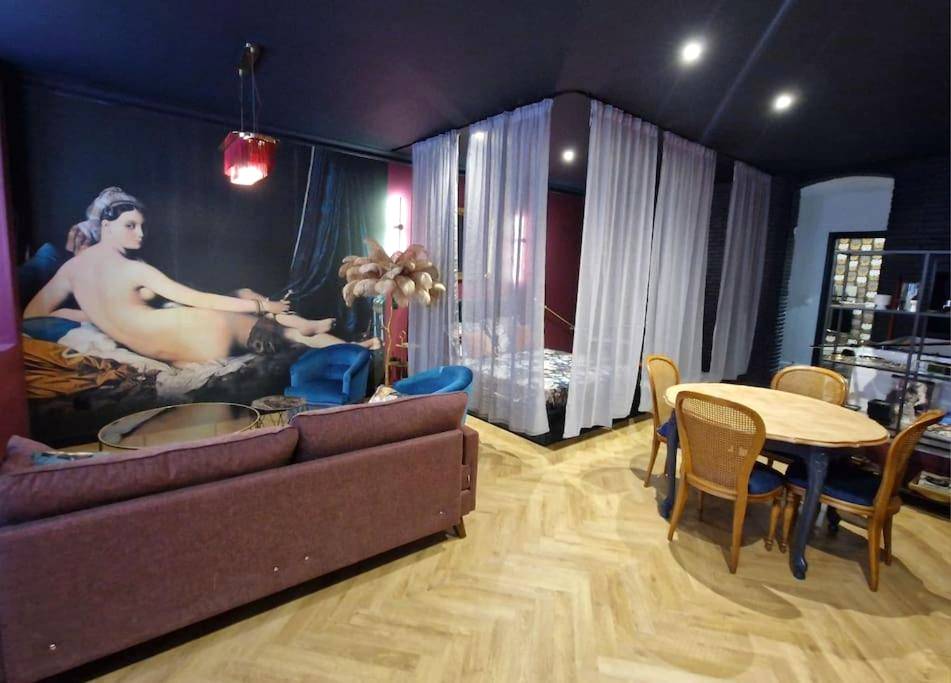 Salon avec fresque murale et coin repas - Love Room Montauban - Le Boudoir D'Olympe Appartement érotico - romantique