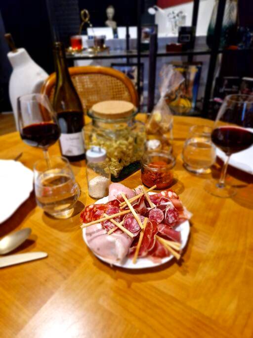 Planche de charcuterie et vin sur table en bois - Le Boudoir D'Olympe Appartement érotico - romantique