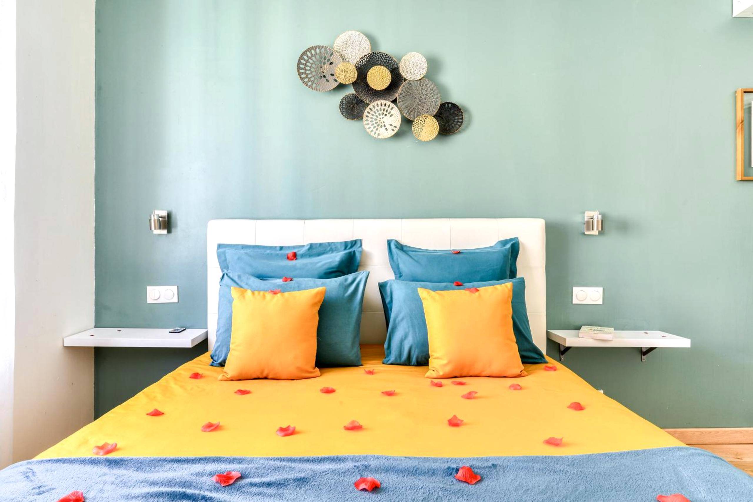 Lit avec pétales de roses et coussins colorés - Le bourget - Suite romantique