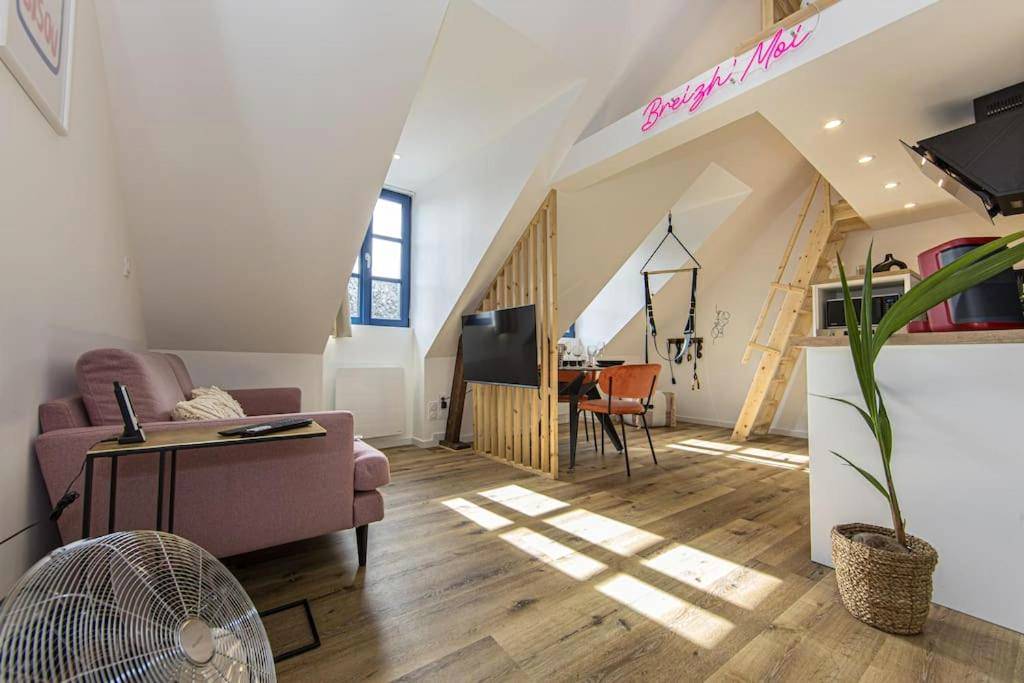 Salon avec canapé rose et néon lumineux - La Breizh moi Balnéo Love Room
