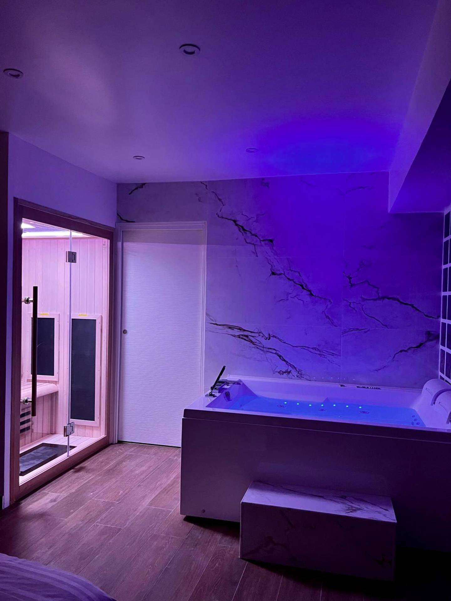 Jacuzzi et sauna avec éclairage néon violet - Love Room Triel - sur - Seine - Bulle Evasion
