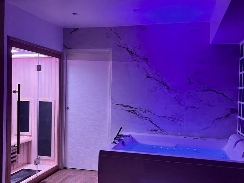 Jacuzzi et sauna avec éclairage néon violet - Love Room Triel - sur - Seine - Bulle Evasion