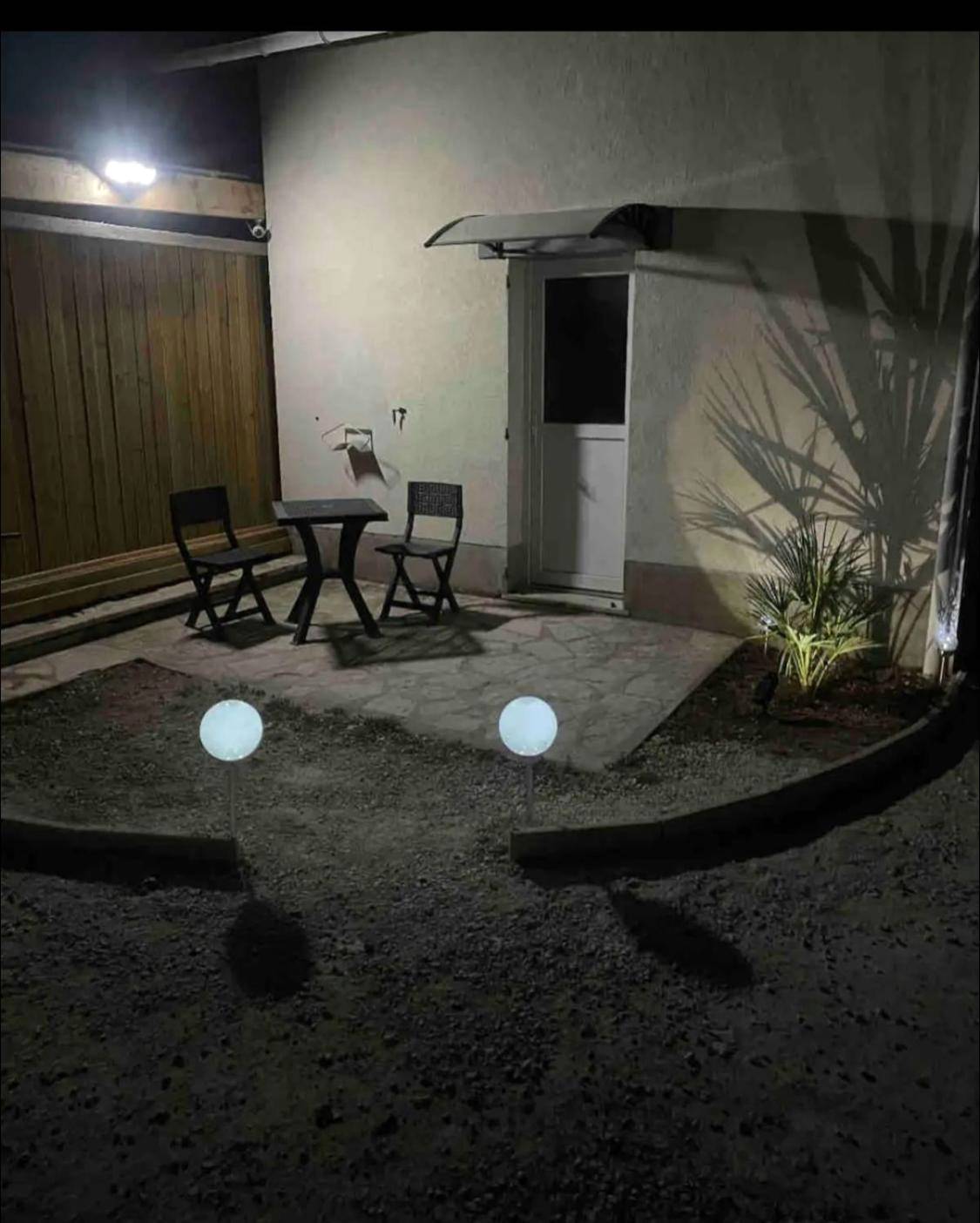 Terrasse extérieure de nuit avec mobilier noir - La Bulle de Romance - Love Room
