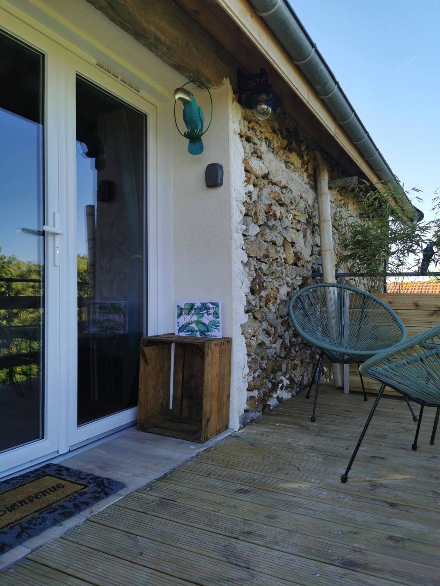 Terrasse en bois avec fauteuils et mur en pierre - La bulle suspendue