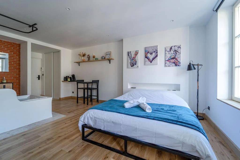 Lit double avec chemin de lit bleu et serviettes - Love Room Nancy - La bulle urbaine