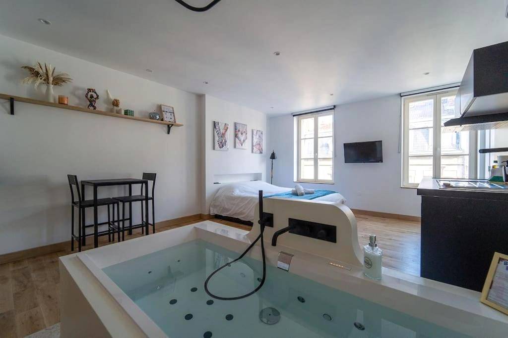 Baignoire balnéo privative face au lit - La bulle urbaine