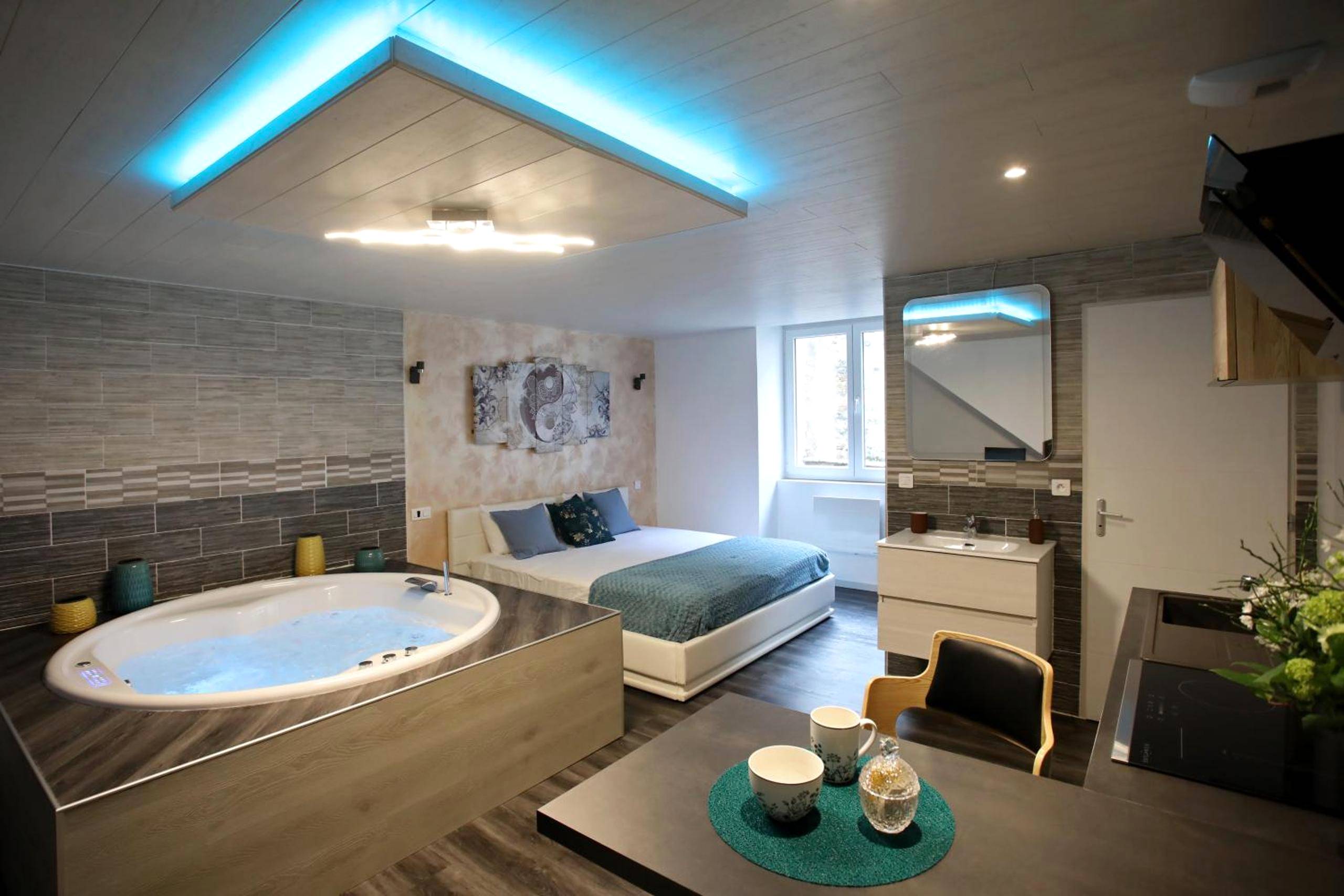 Jacuzzi privatif et lit double avec néon bleu - Bulles Emotions