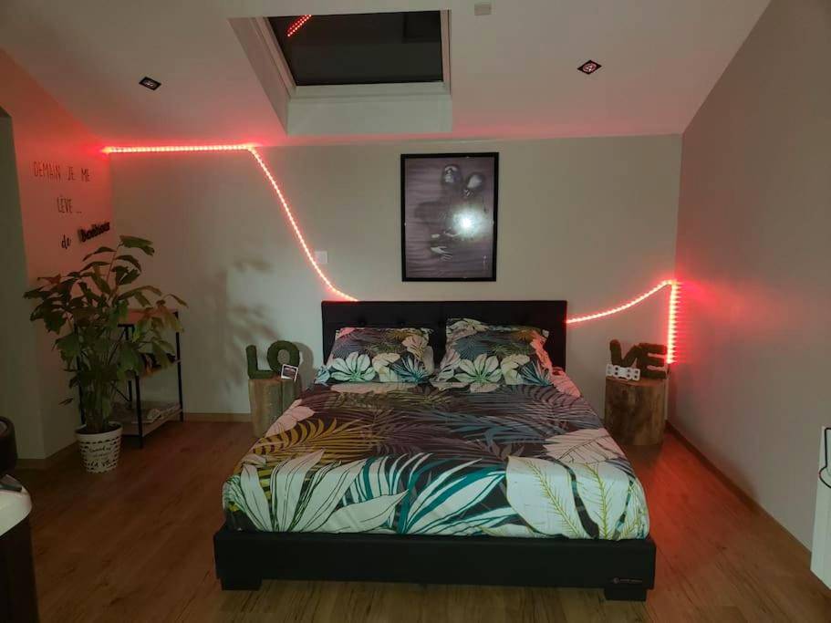 Lit double avec parure tropicale et néon rouge - Bulles étoilées Appartement avec jacuzzi privé