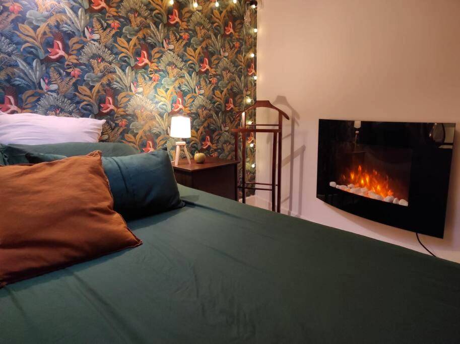 Lit double face à une cheminée électrique - La Cabana Agréable logement avec Jacuzzi/Balnéo