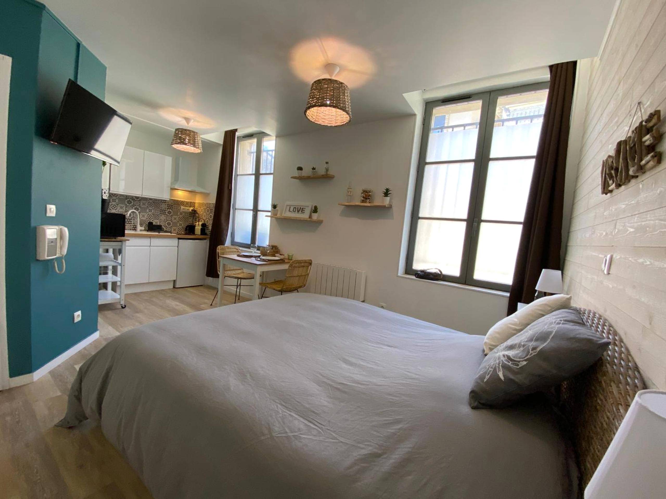 Lit double confortable et espace cuisine équipée - La cabane voyage