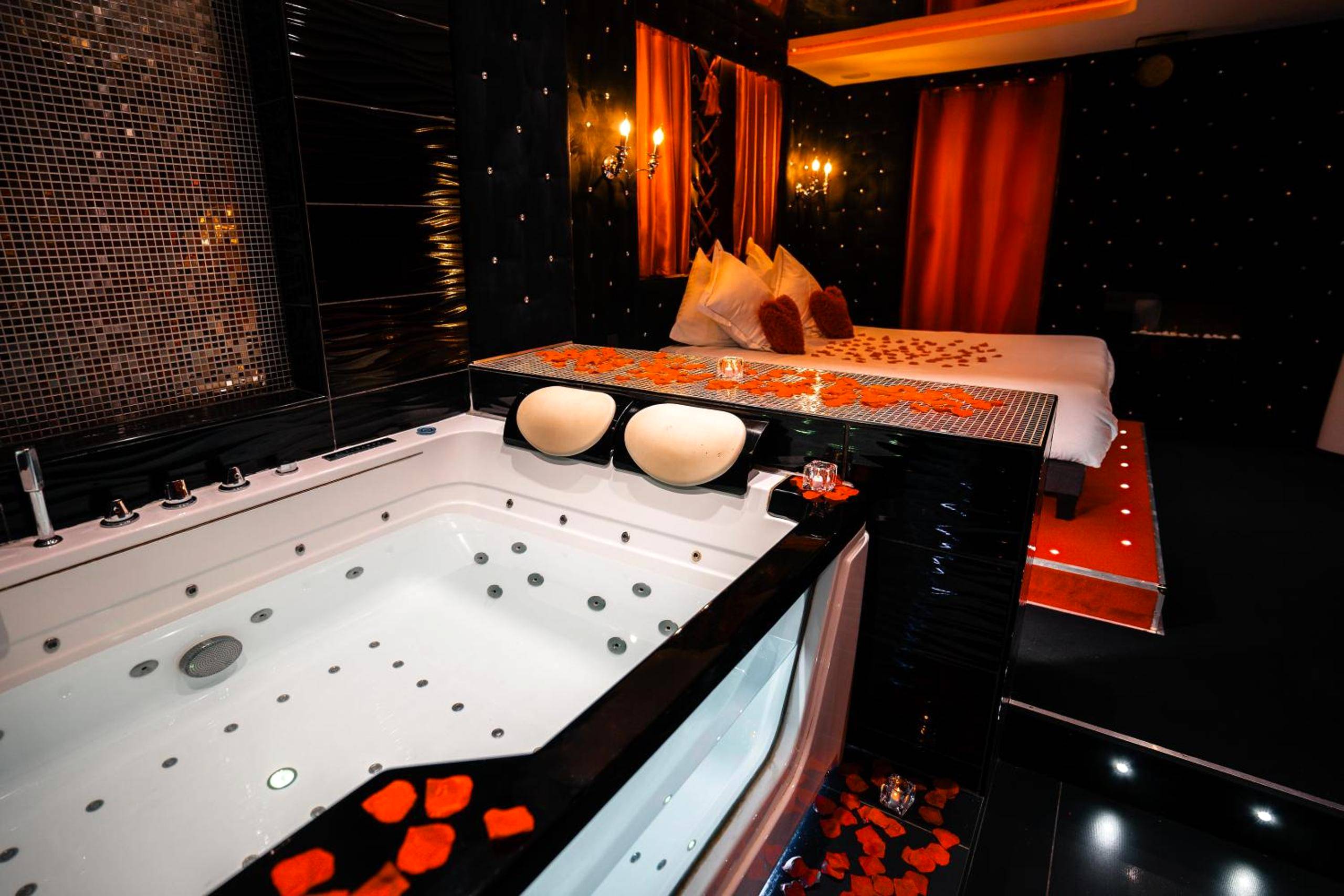 Jacuzzi privatif et lit avec pétales de rose - Love Room Lyon - Le Cabaret Vip SPA