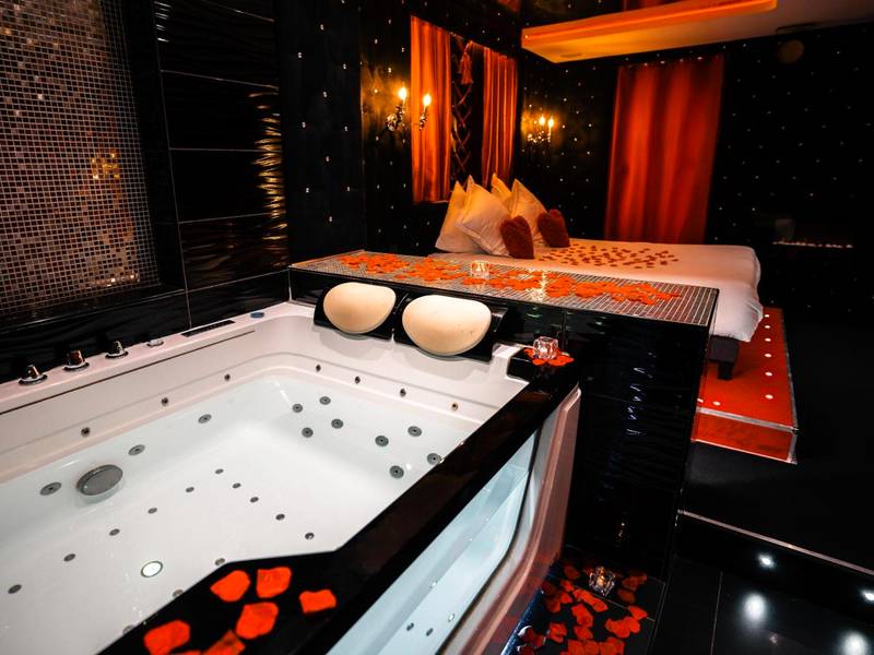 Jacuzzi privatif et lit avec pétales de rose - Love Room Lyon - Le Cabaret Vip SPA