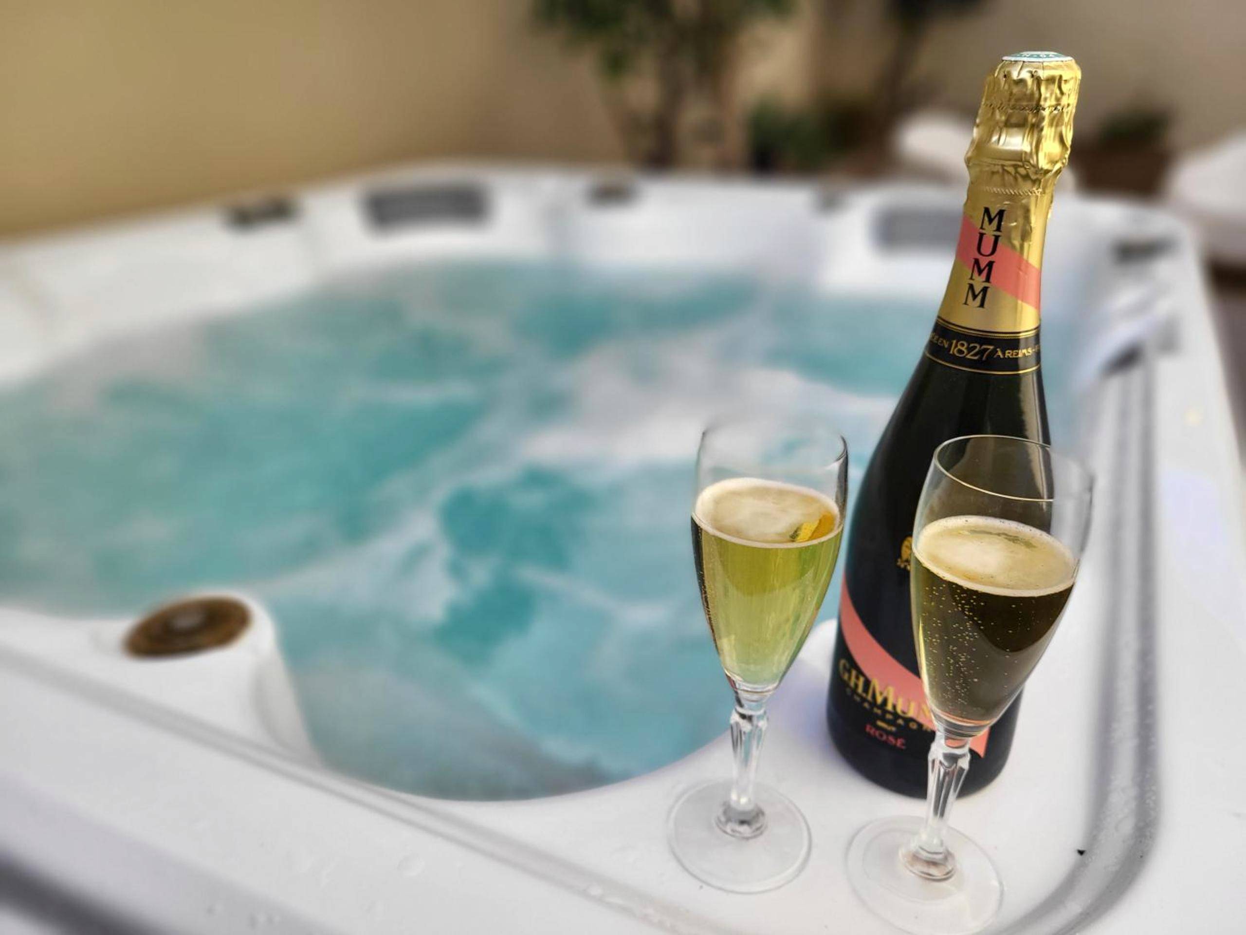 Bouteille de champagne et flûtes au bord du spa - les Cachottiers Montélimar