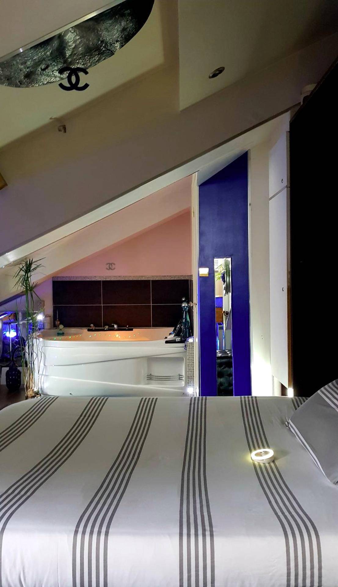 Chambre avec lit rayé et jacuzzi en arrière - plan - CANNES TOIT ET MOI